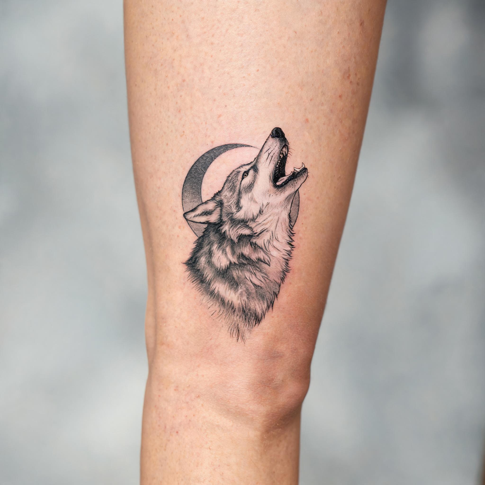 A black and grey illustrative tattoo of meaningful imagery inked on the front thigh, shown on real skin against a clean neutral background.
