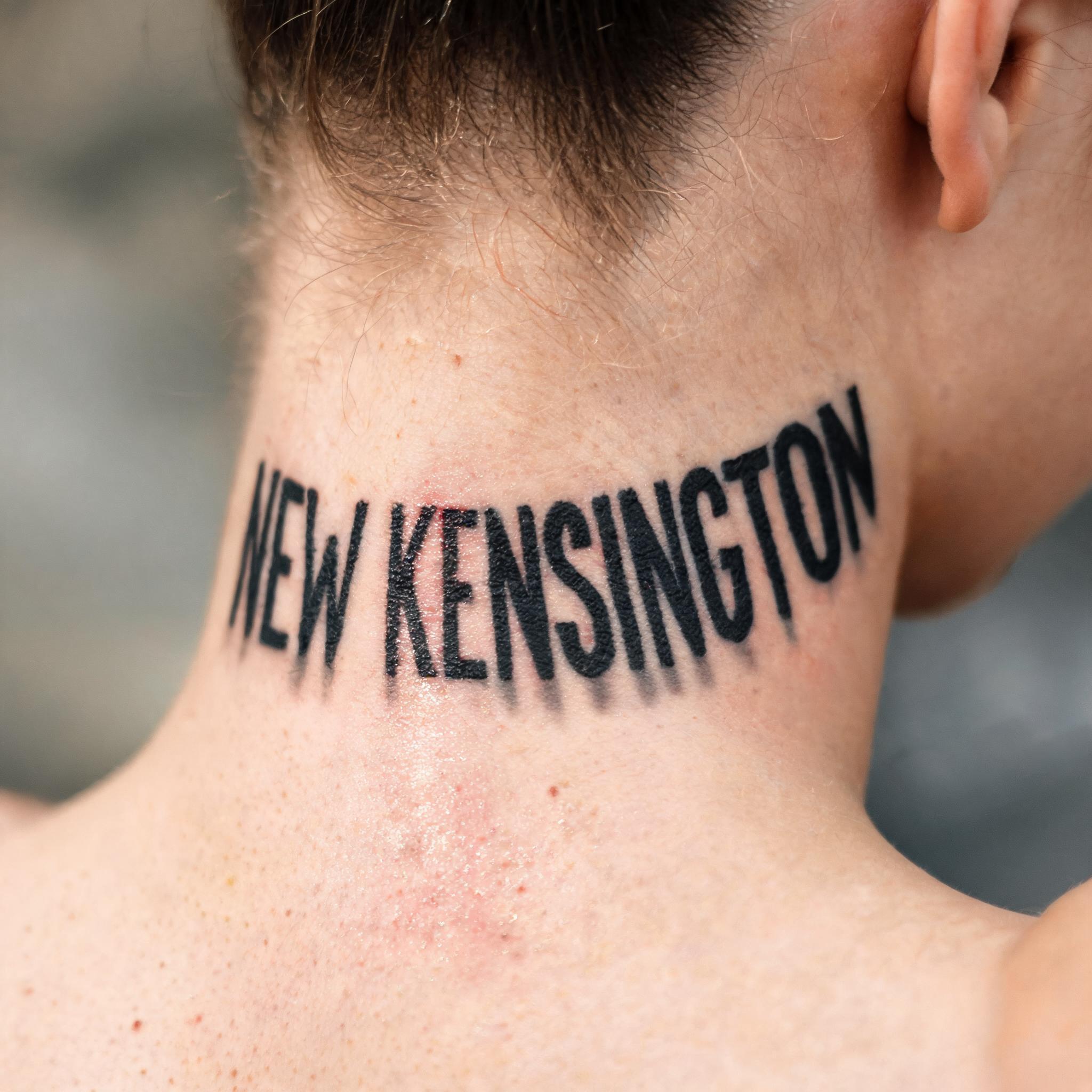 Blackwork true image tattoo on the nape and side of the neck, shown in a close-up photo against a plain background.