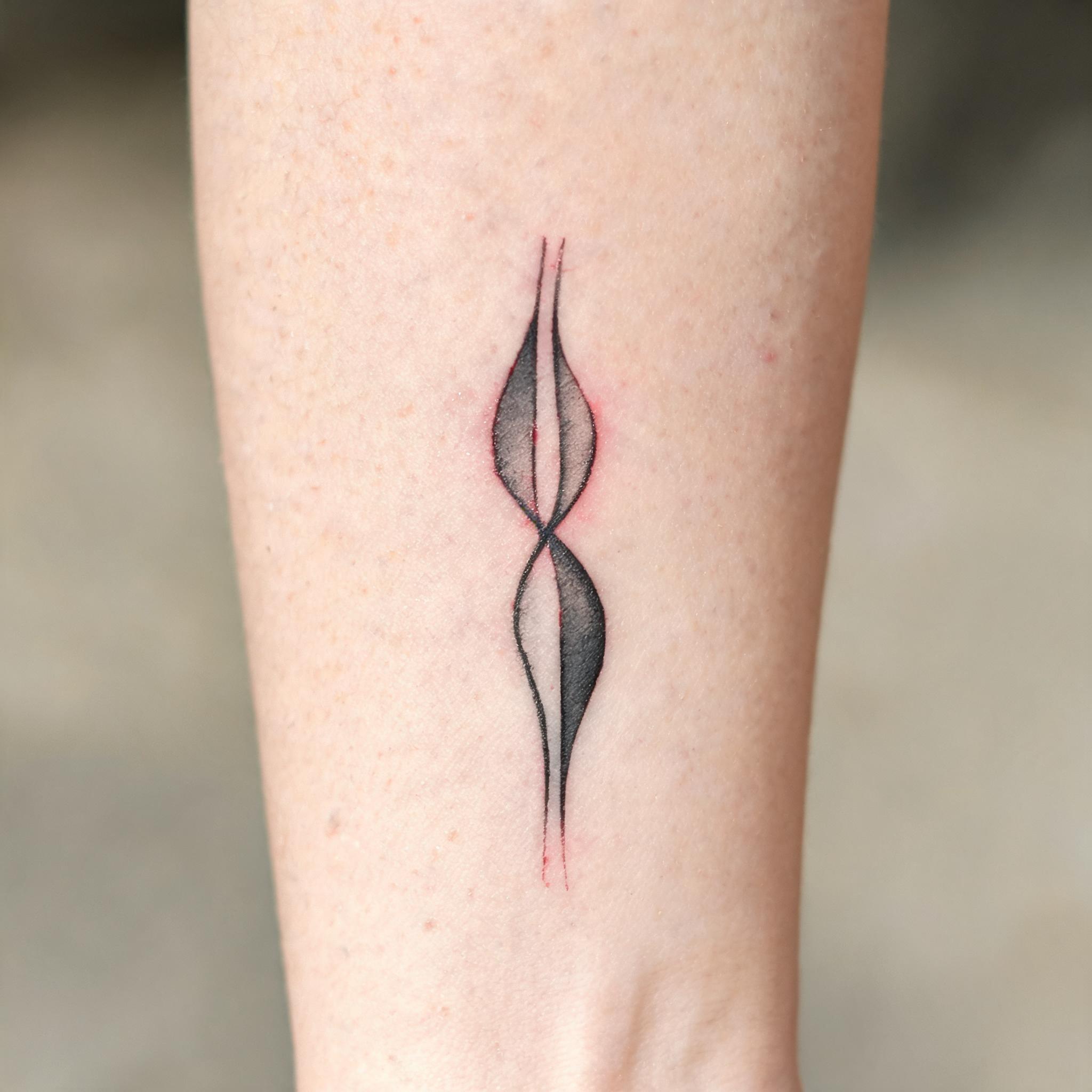 A minimalist 3d tattoo images tattoo in black and grey ink on a person's inner forearm, photographed on a clean neutral background.