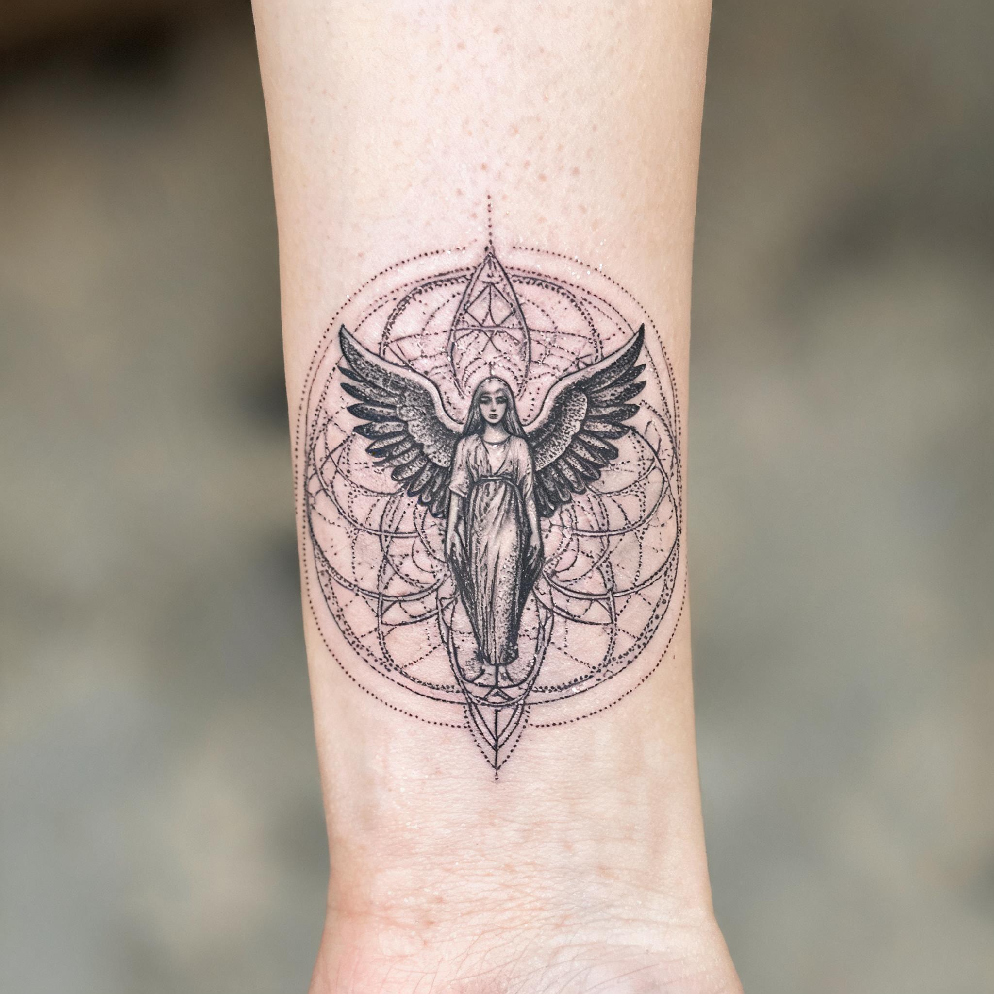 Geometric dotwork angel tattoo on an inner forearm, black and grey ink, shown as a tattoo image against neutral background.