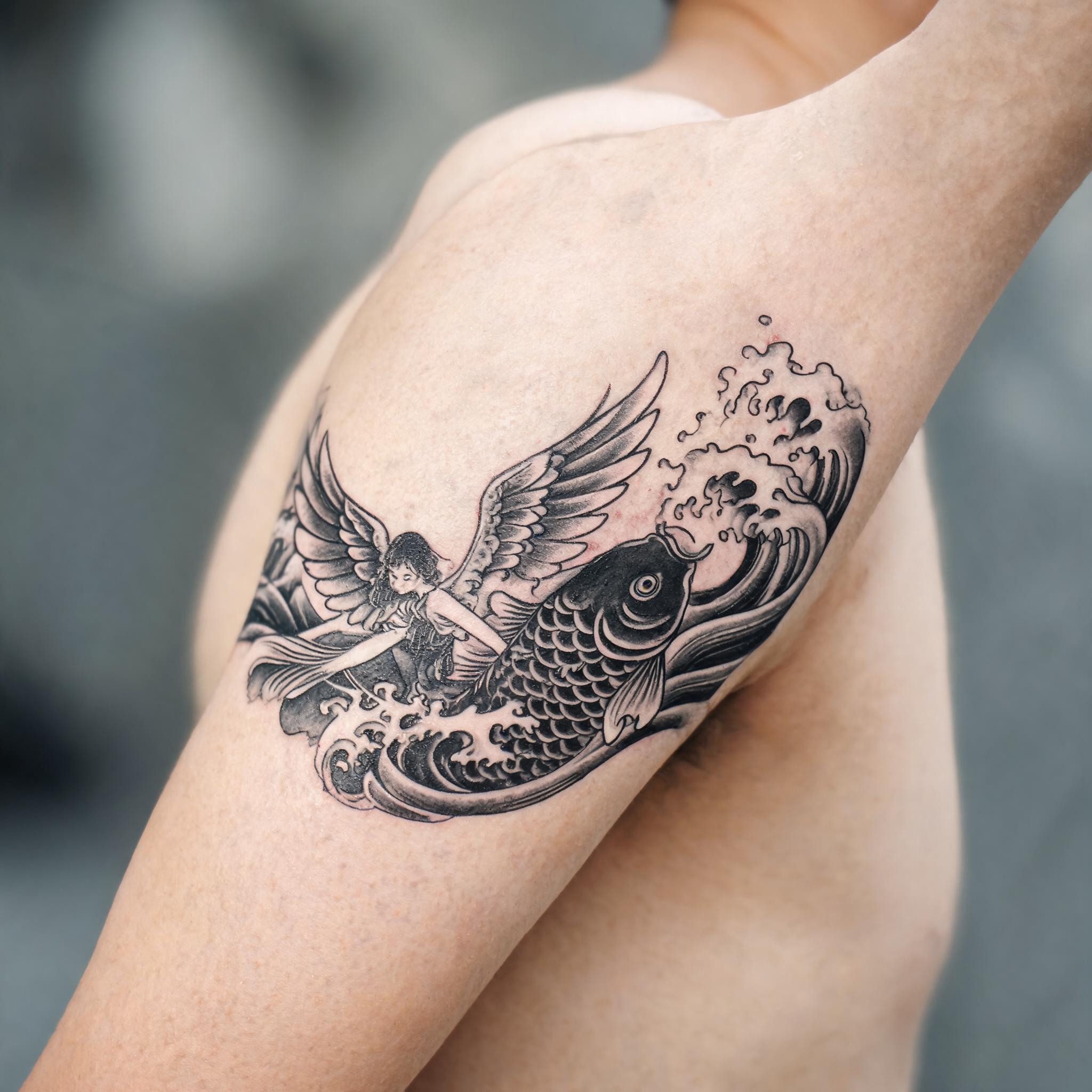 Black and grey Japanese irezumi fairy wings tattoo image design on a person's inner bicep, shown on a plain background.