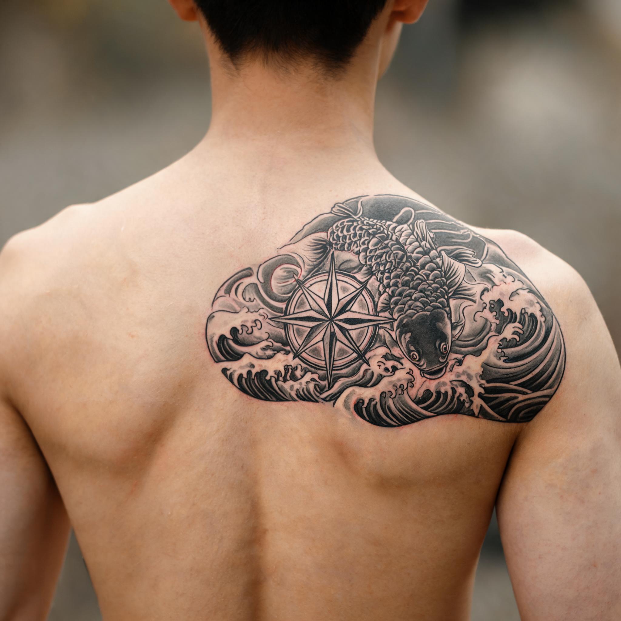 A nautical compass tattoo image design in Japanese irezumi style on a shoulder blade, shown as a tattoo photo against a neutral background.